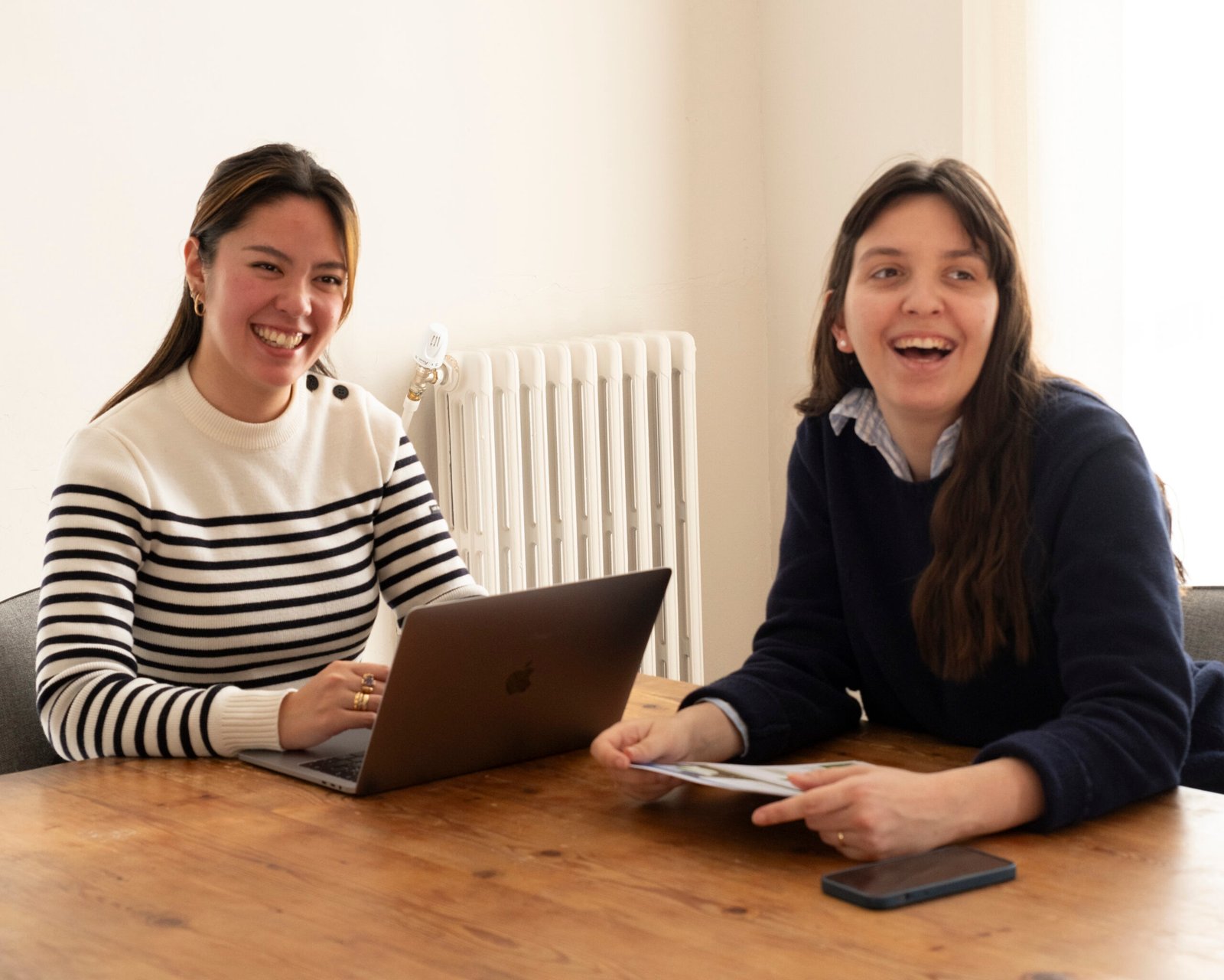 Domitille et Pauline, de l’Agence Acutis, souriantes autour d’une table de travail