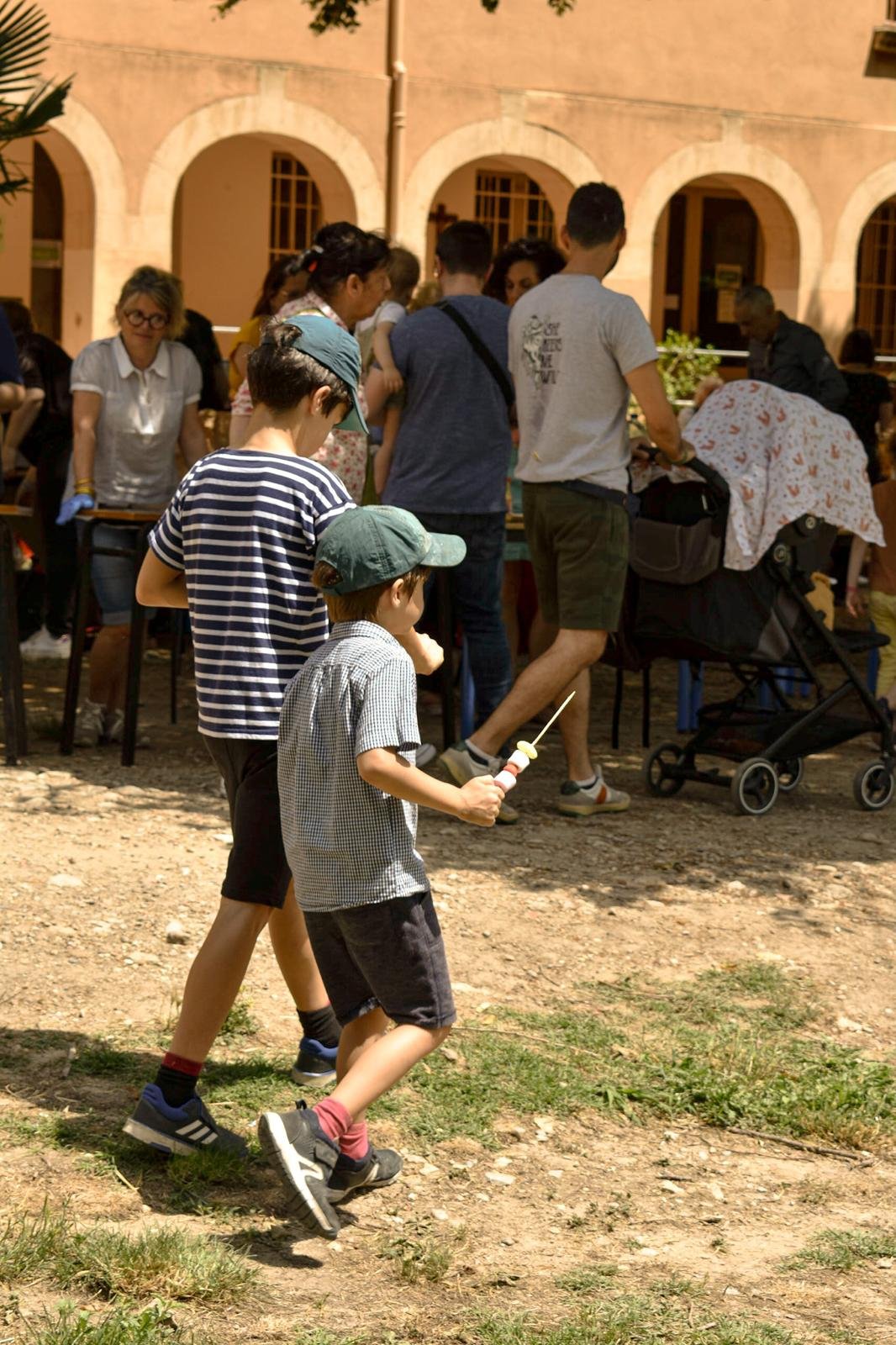 Des enfants et des familles réunis devant les arcades de la Maison du Carmel